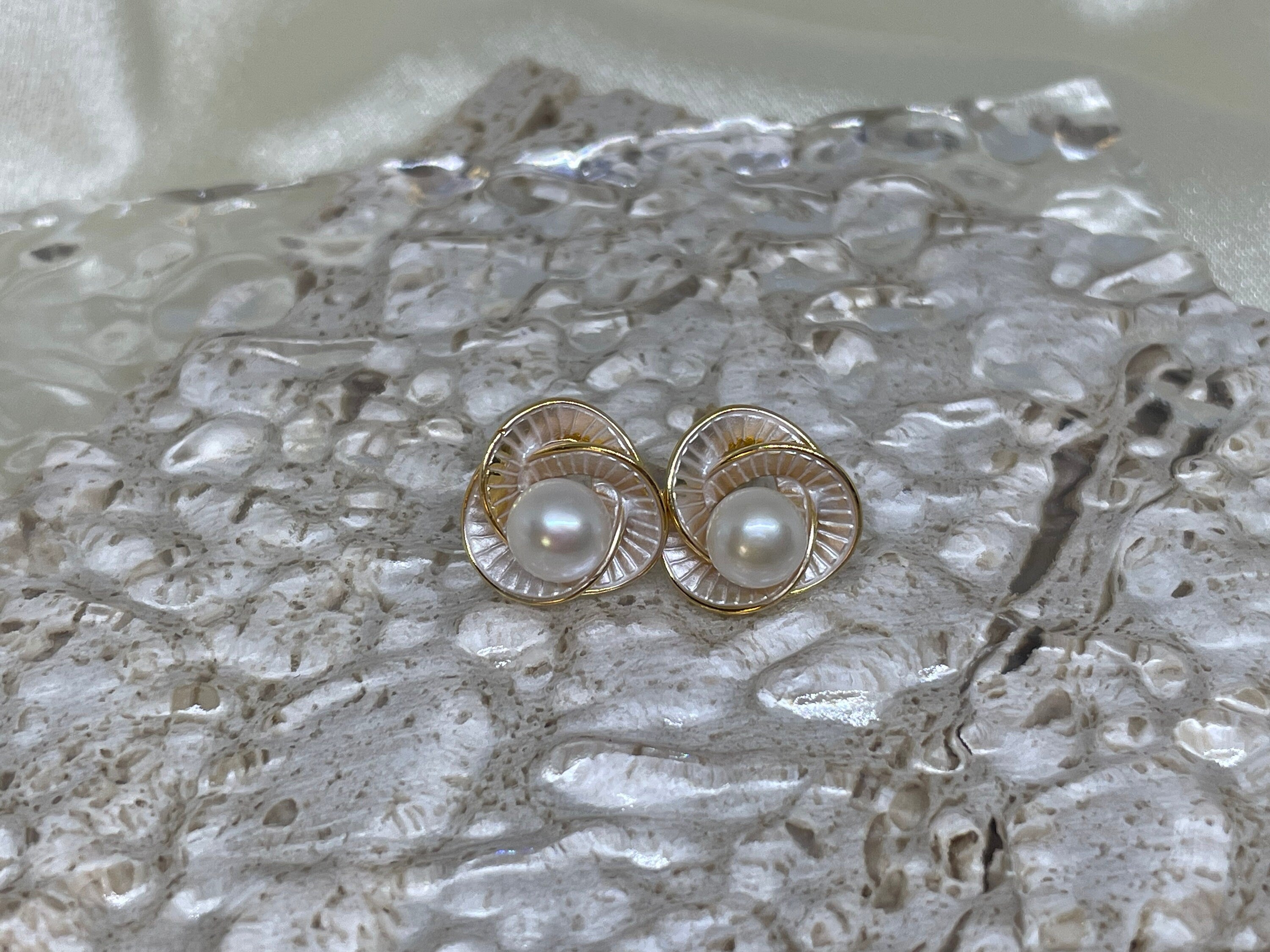 CAELLIA Camellia flower stud earrings featuring a central freshwater pearl in a gold trifoil design.