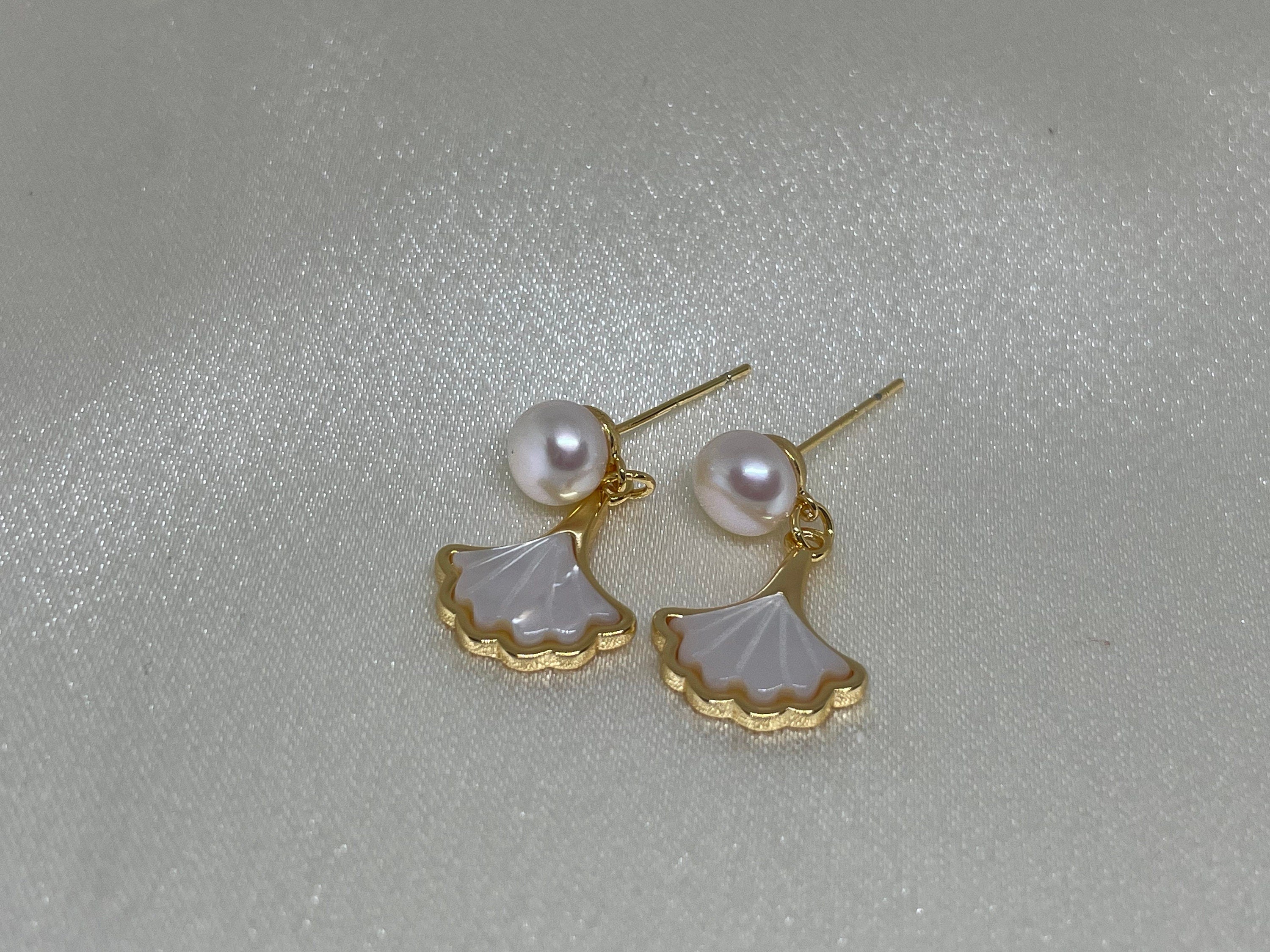 Caellia 14K gold earrings featuring a freshwater pearl and a mother-of-pearl fan charm.