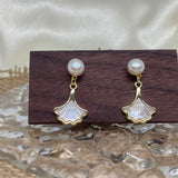 Caellia 14K gold earrings featuring a freshwater pearl stud and a mother-of-pearl fan dangle.