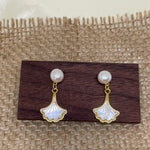Caellia 14K gold earrings featuring a freshwater pearl stud and a mother-of-pearl fan drop.