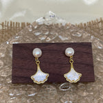 Caellia 14K gold earrings featuring a freshwater pearl stud and a mother-of-pearl fan drop.