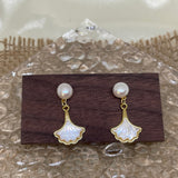 Caellia 14K gold earrings featuring a freshwater pearl stud and a mother-of-pearl fan drop.