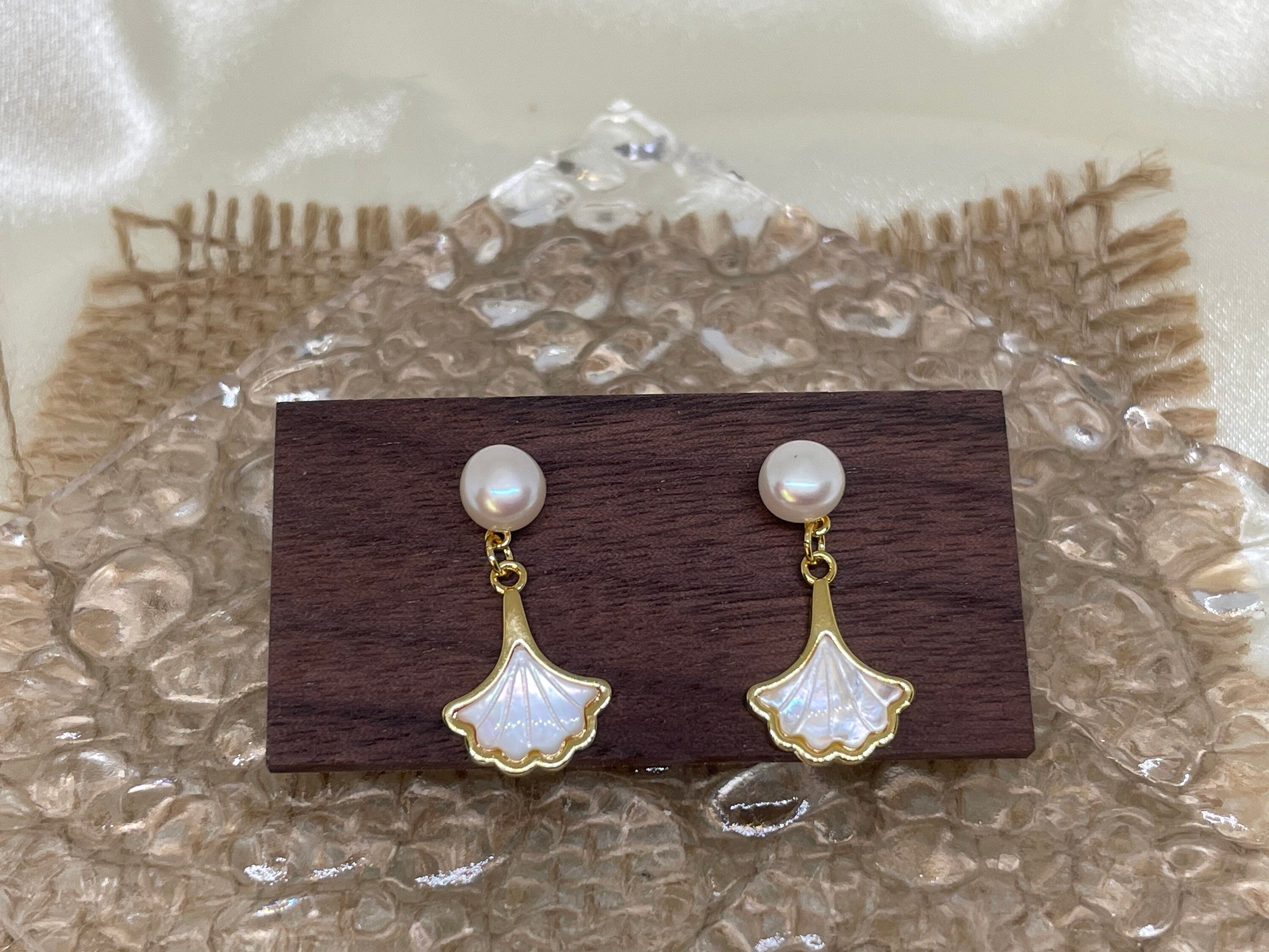 Caellia 14K gold earrings featuring a freshwater pearl stud and a mother-of-pearl fan drop.