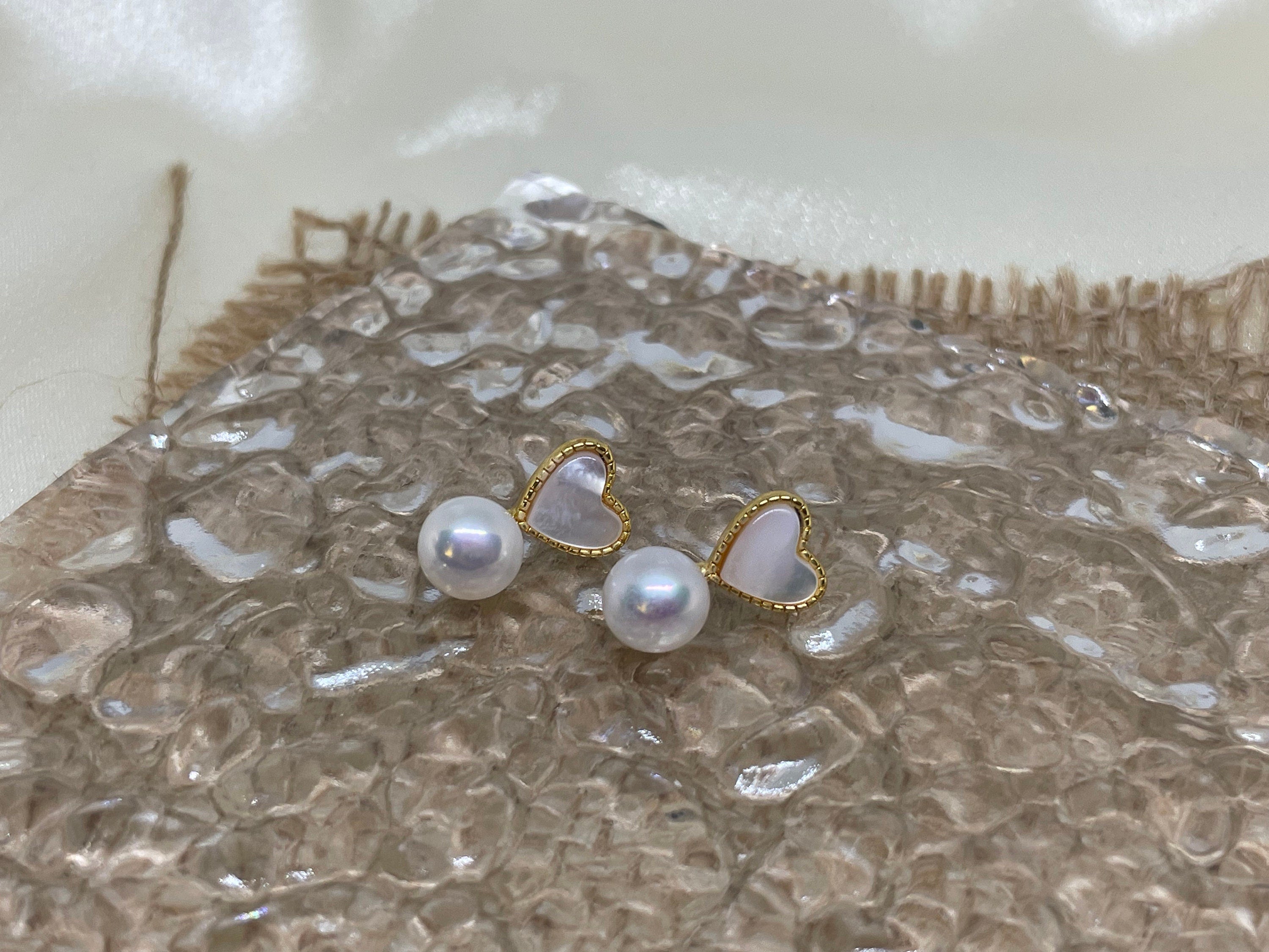 Caellia 14K gold stud earrings featuring a heart-shaped fritillaria shell and a freshwater pearl.