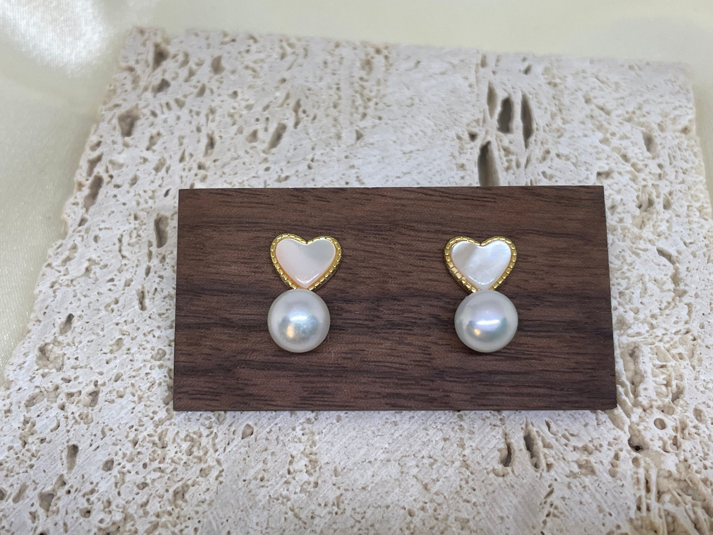 Caellia 14K gold stud earrings featuring a heart-shaped fritillaria shell above a freshwater pearl.