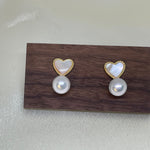 Caellia 14K gold stud earrings featuring a heart-shaped fritillaria shell above a freshwater pearl.