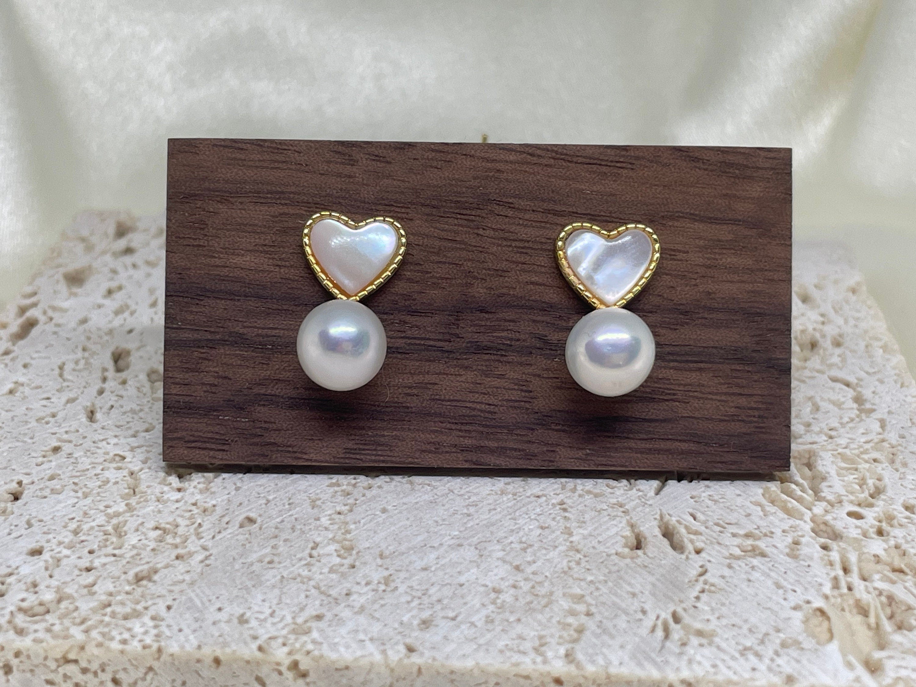 Caellia 14K gold stud earrings featuring a heart-shaped fritillaria shell above a freshwater pearl.