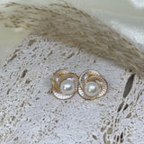 Caellia Camellia flower stud earrings featuring a central freshwater pearl and gold-tone petals.