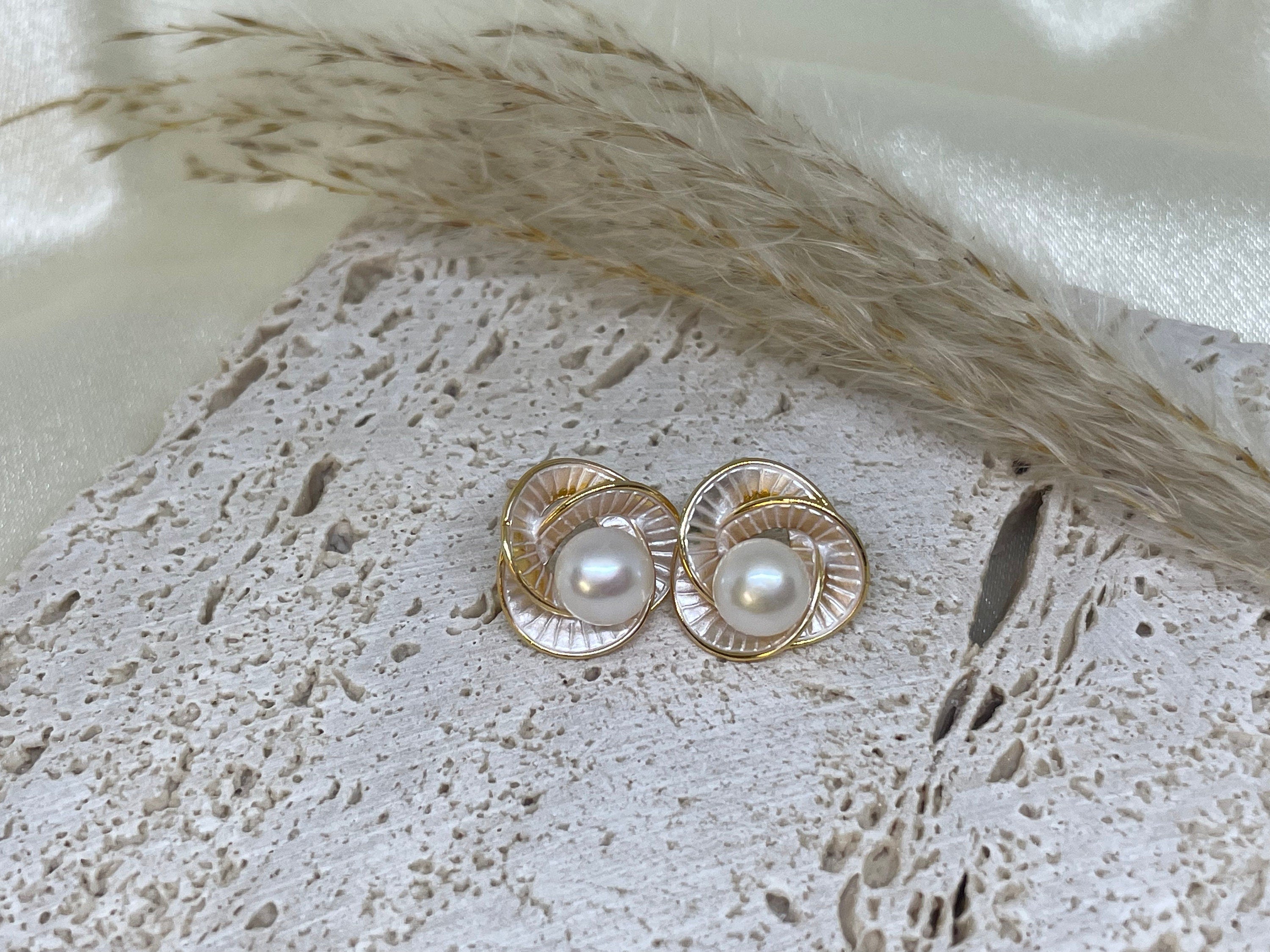 Caellia Camellia flower stud earrings featuring a central freshwater pearl and gold-tone petals.