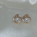 CAELLIA stud earrings featuring a freshwater pearl centered in a trifoil flower design.