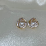 CAELLIA stud earrings featuring a freshwater pearl centered in a trifoil flower design.