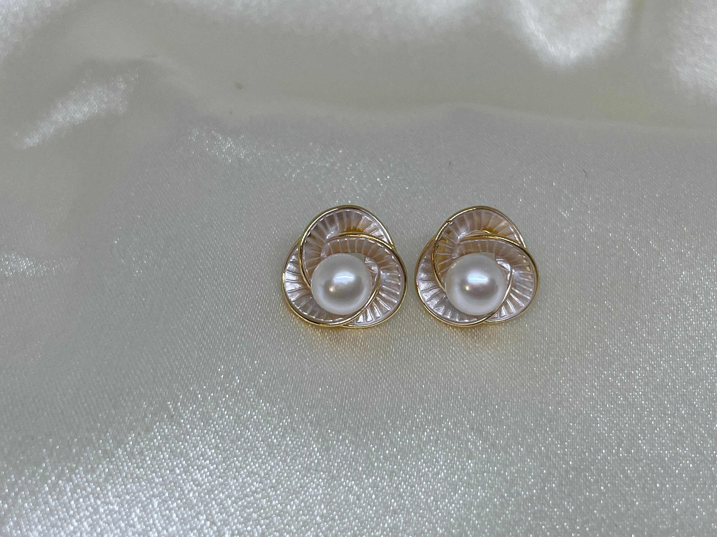 CAELLIA stud earrings featuring a freshwater pearl centered in a trifoil flower design.