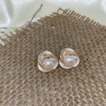 A pair of gold-tone CAELLIA flower stud earrings featuring a central freshwater pearl.