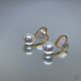 Caellia 14K gold stud earrings featuring a freshwater pearl paired with a heart-shaped shell.