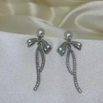 CAELLIA sterling silver dangle earrings featuring a pearl-topped bow and a crystal-lined drop.