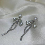 CAELLIA pearl bow dangle earrings crafted in 925 sterling silver with crystal accents.