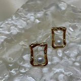 CAELLIA gold plated stud earrings featuring a lustrous freshwater pearl in a textured square frame.