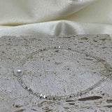 CAELLIA freshwater pearl and 925 sterling silver beaded bracelet on a textured stone surface.