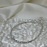 CAELLIA freshwater pearl and 925 sterling silver bracelet on a textured glass surface.