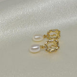 CAELLIA freshwater pearl and gold-plated rose earrings on a white satin background.