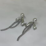 CAELLIA sterling silver dangle earrings featuring a freshwater pearl and a crystal-accented bow.