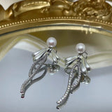 CAELLIA sterling silver dangle earrings featuring a pearl bow design with pavé accents.