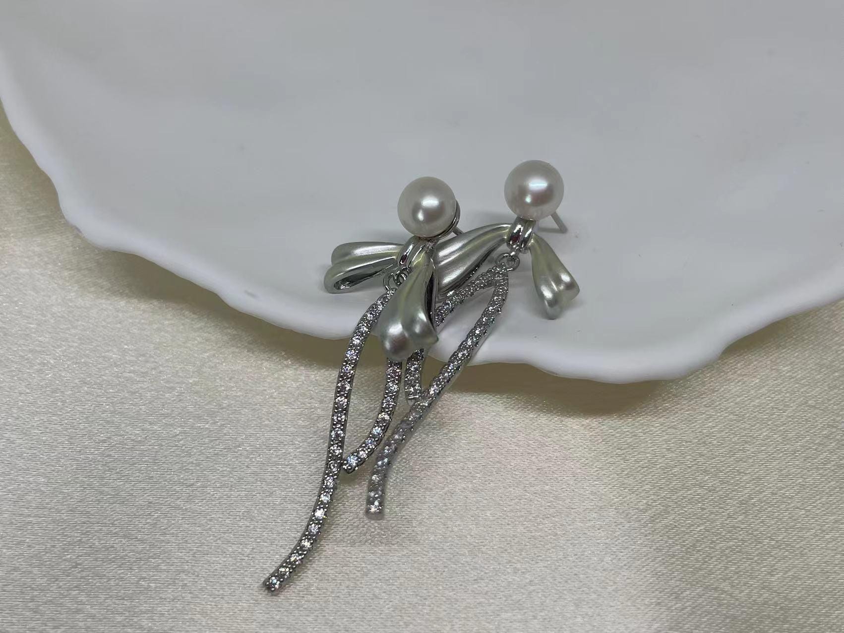 CAELLIA pearl bow dangle earrings crafted from 925 sterling silver with freshwater pearls.