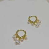 Caellia 14K gold huggie hoop earrings featuring delicate dangling freshwater pearls.