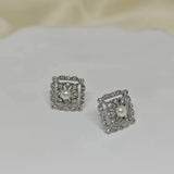 CAELLIA sterling silver square stud earrings featuring a central pearl framed by small diamonds.