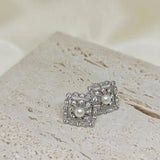 CAELLIA sterling silver square stud earrings featuring a central freshwater pearl and diamond accents.