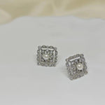 CAELLIA sterling silver square stud earrings featuring a central freshwater pearl and diamond accents.