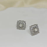 CAELLIA sterling silver square stud earrings featuring a central freshwater pearl and diamond accents.