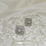 CAELLIA sterling silver square stud earrings featuring a central freshwater pearl and diamond accents.