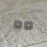 CAELLIA sterling silver square stud earrings featuring a central freshwater pearl and diamond accents.