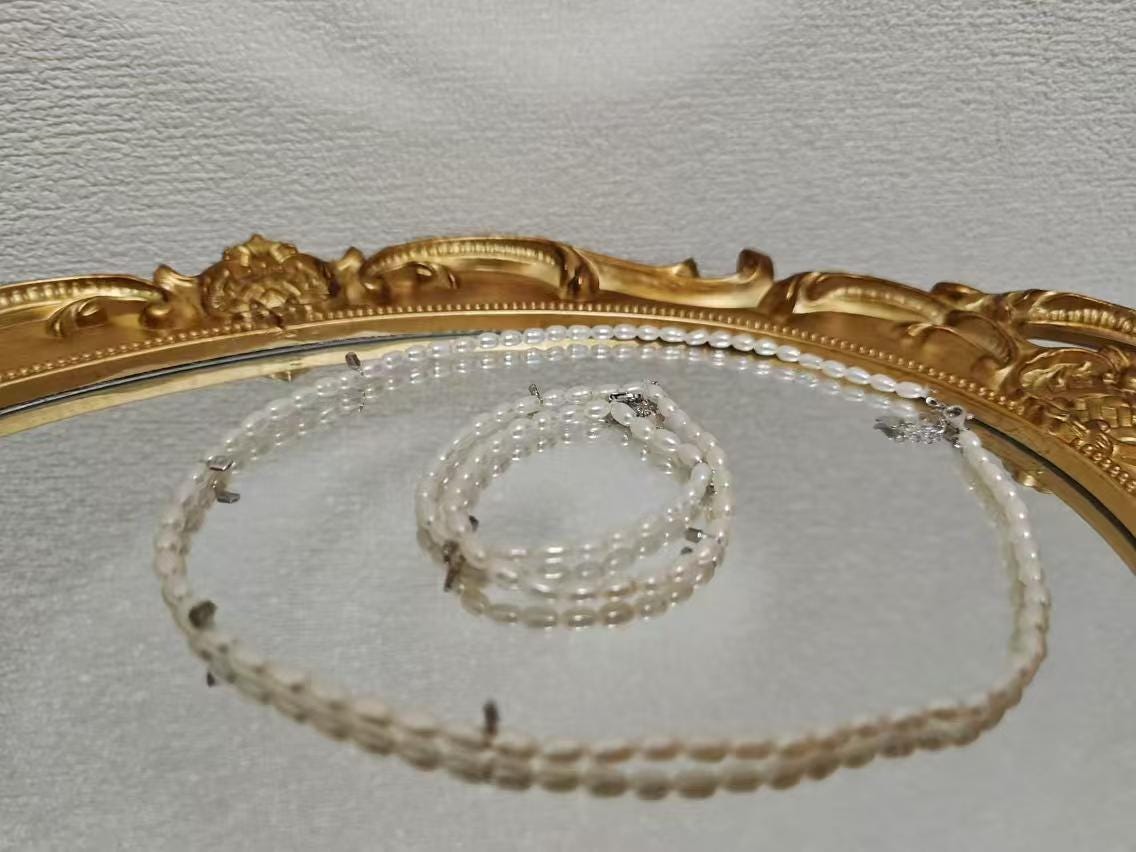 A Caellia freshwater pearl necklace with AAA grade beads displayed on a gold-rimmed mirror.