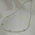 A delicate Caellia freshwater pearl necklace featuring small white beads on a silver chain.