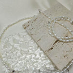 A Caellia freshwater pearl necklace with AAA grade beads resting on a textured stone surface.