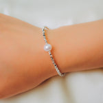 A CAELLIA freshwater pearl bracelet on a 925 sterling silver chain worn on a wrist.