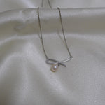 CAELLIA dainty freshwater pearl pendant necklace featuring a delicate bow design on a silver chain.