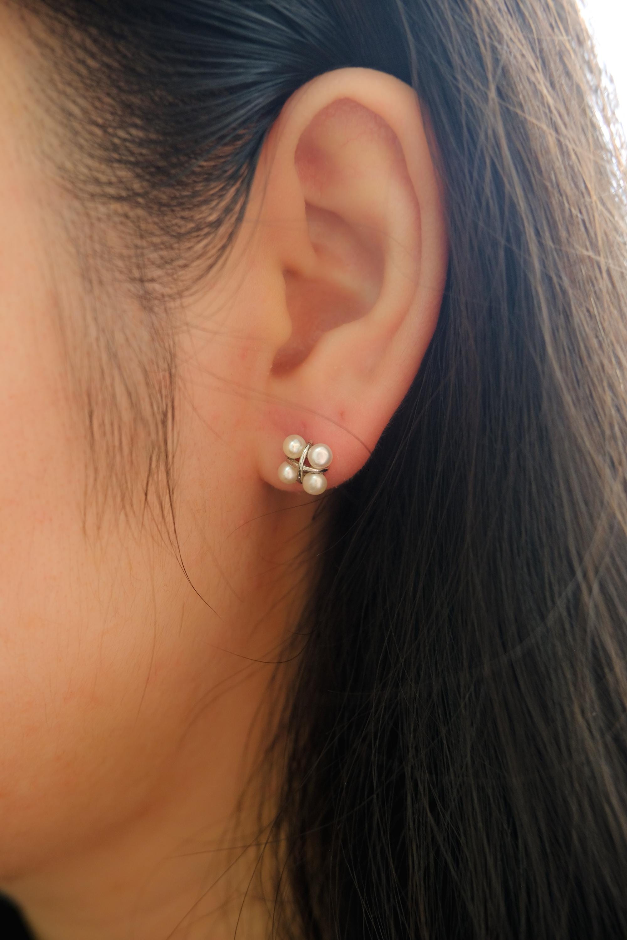 CAELLIA freshwater pearl rhomboid stud earrings worn on an earlobe.