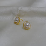 CAELLIA gold plated freshwater pearl earrings featuring a minimalist circular frame design.