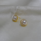 CAELLIA gold plated freshwater pearl earrings featuring a minimalist circular frame design.