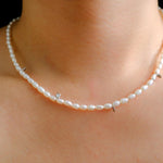 A Caellia freshwater pearl bead necklace with small silver accents worn around the neck.