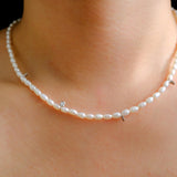 A Caellia freshwater pearl bead necklace with small silver accents worn around the neck.