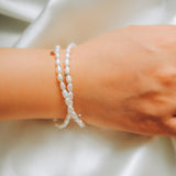 A CAELLIA double wrapped freshwater pearl bracelet with sterling silver accents on a wrist.