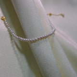 CAELLIA freshwater pearl bracelet with gold plated sterling silver hardware on draped fabric.