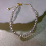 CAELLIA freshwater pearl bracelet with gold plated sterling silver hardware on a white surface.