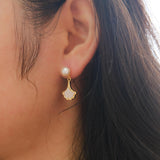 Caellia 14K gold earrings featuring a freshwater pearl stud and a mother-of-pearl fan drop.