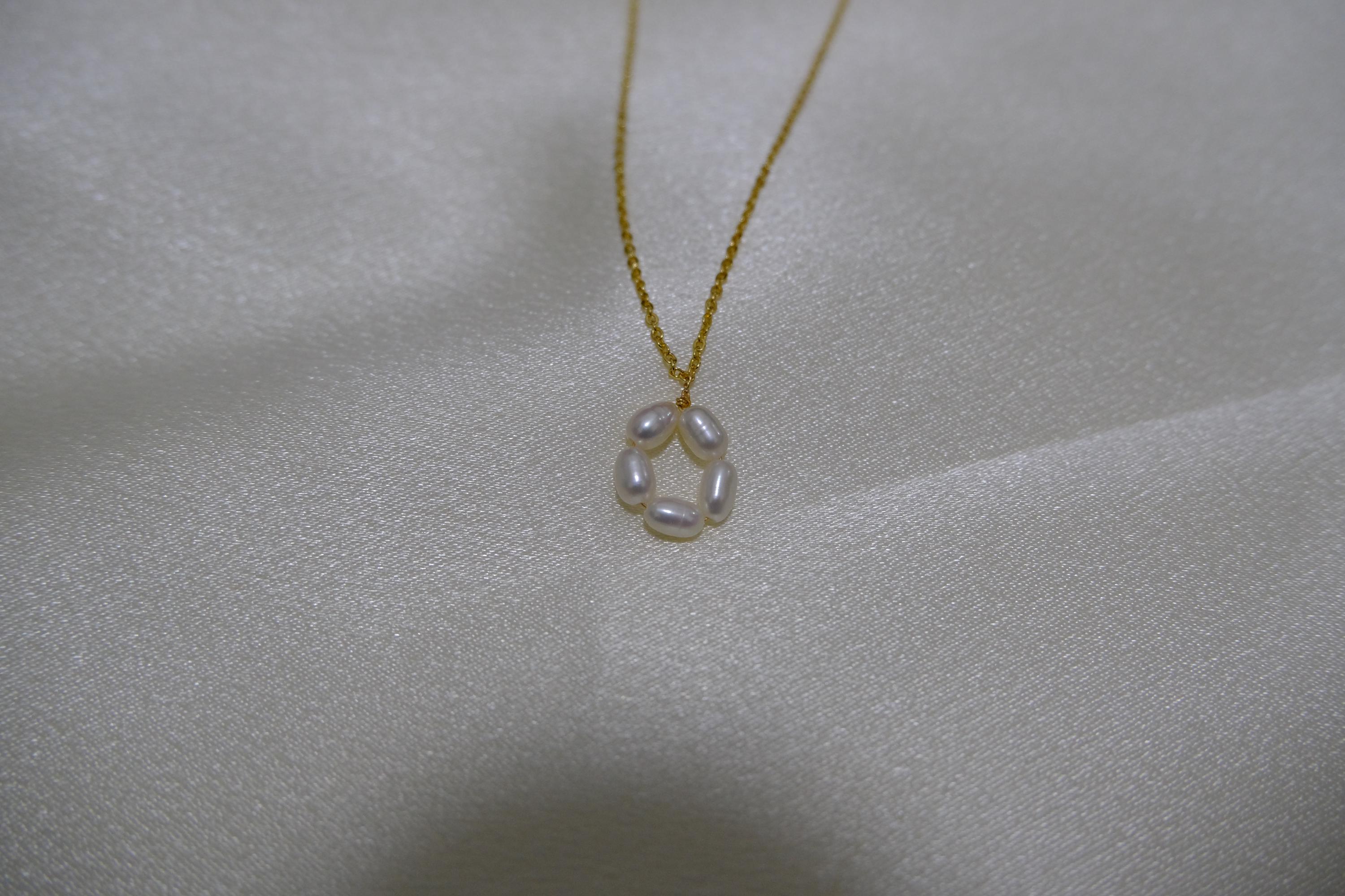 CAELLIA gold plated necklace featuring a delicate flower pendant made of five freshwater pearls.