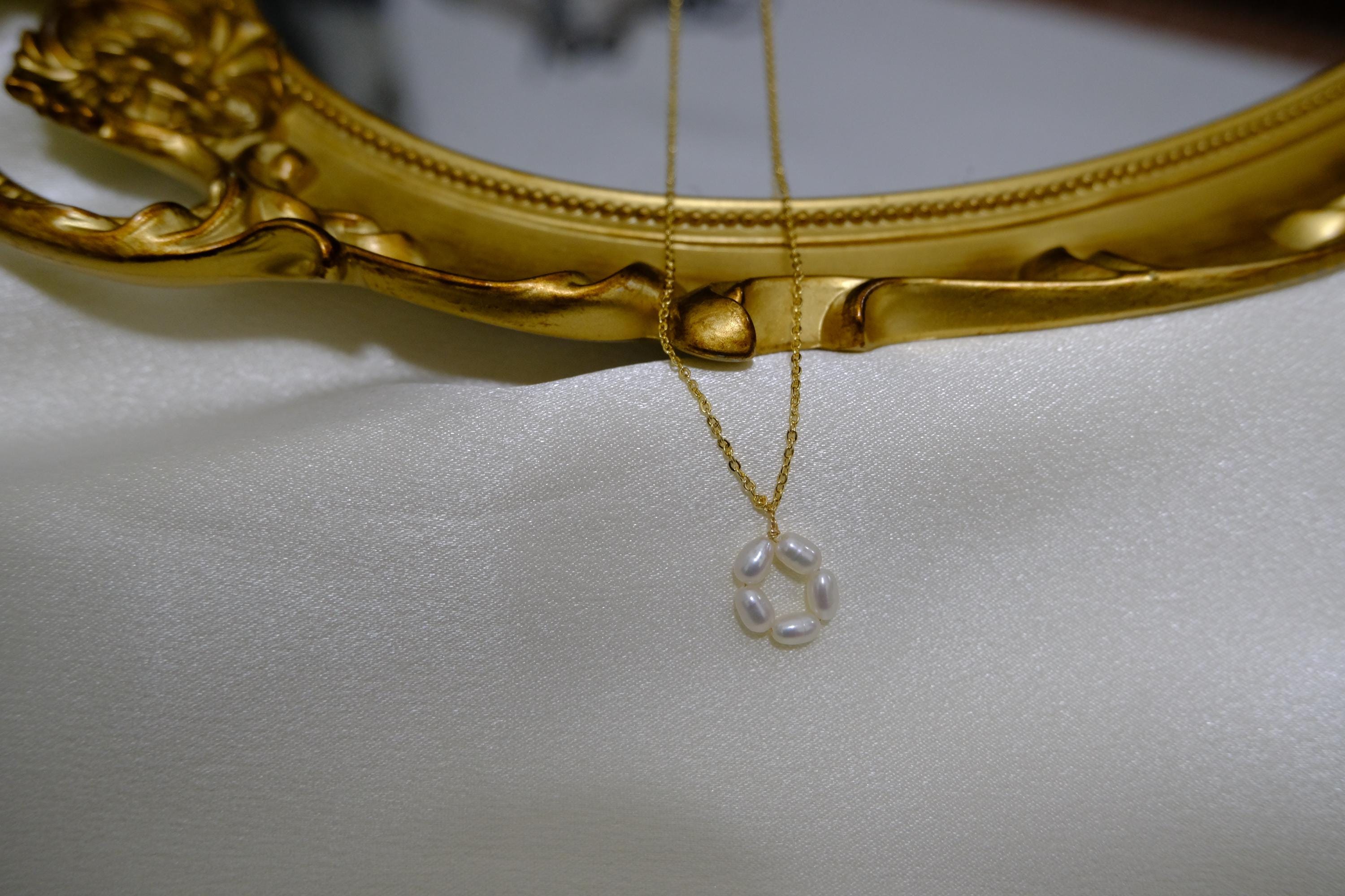 CAELLIA gold plated necklace featuring a delicate flower pendant made of small freshwater pearls.